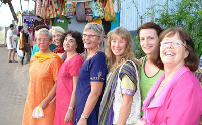 Glada deltagare poserar i indiska saris